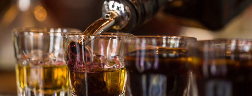 person pouring liquor into glasses - Anytime Bar Supplies Pour Spouts