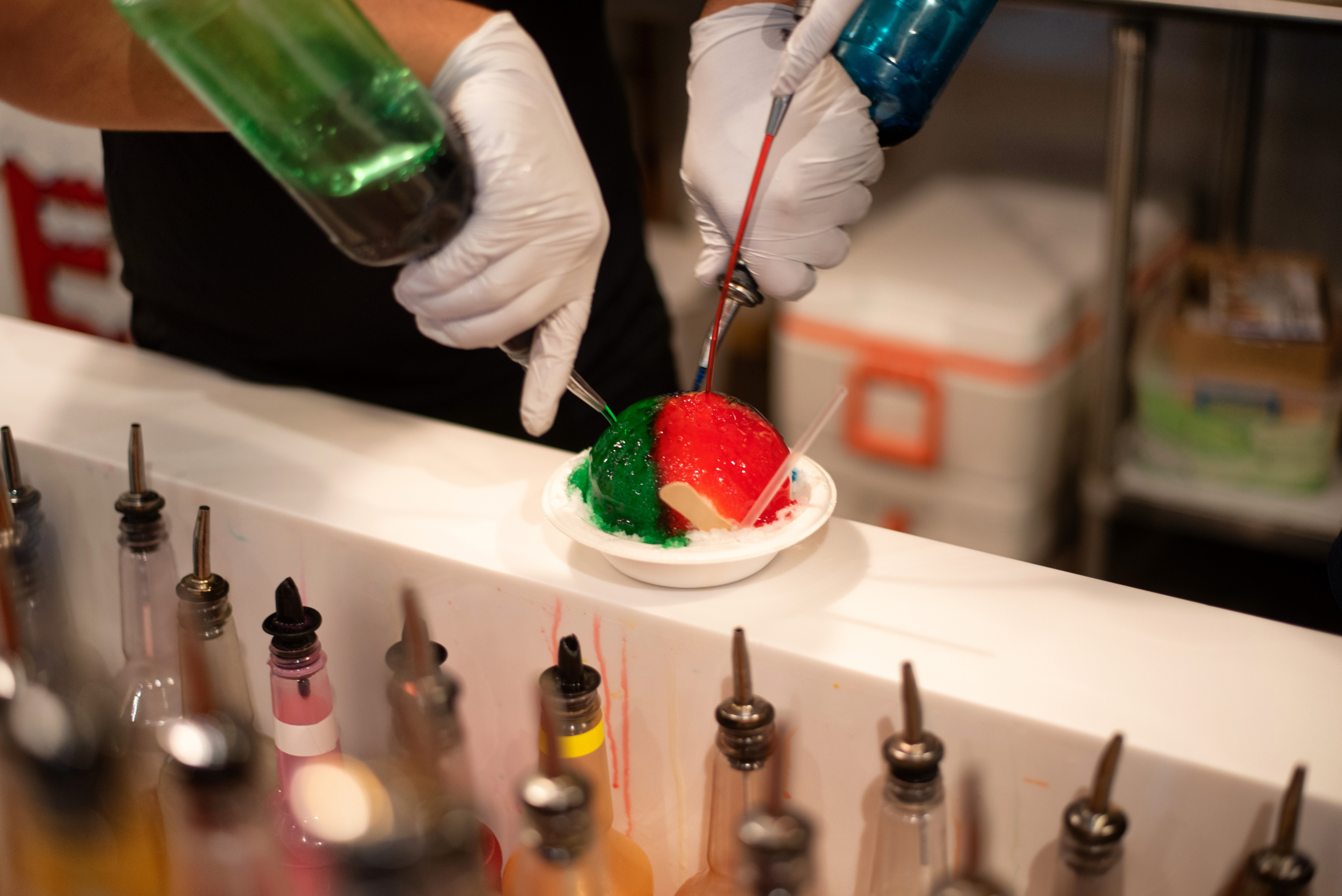 person pouring colorful syrup over ice - Anytime Bar Supplies Pour Spouts