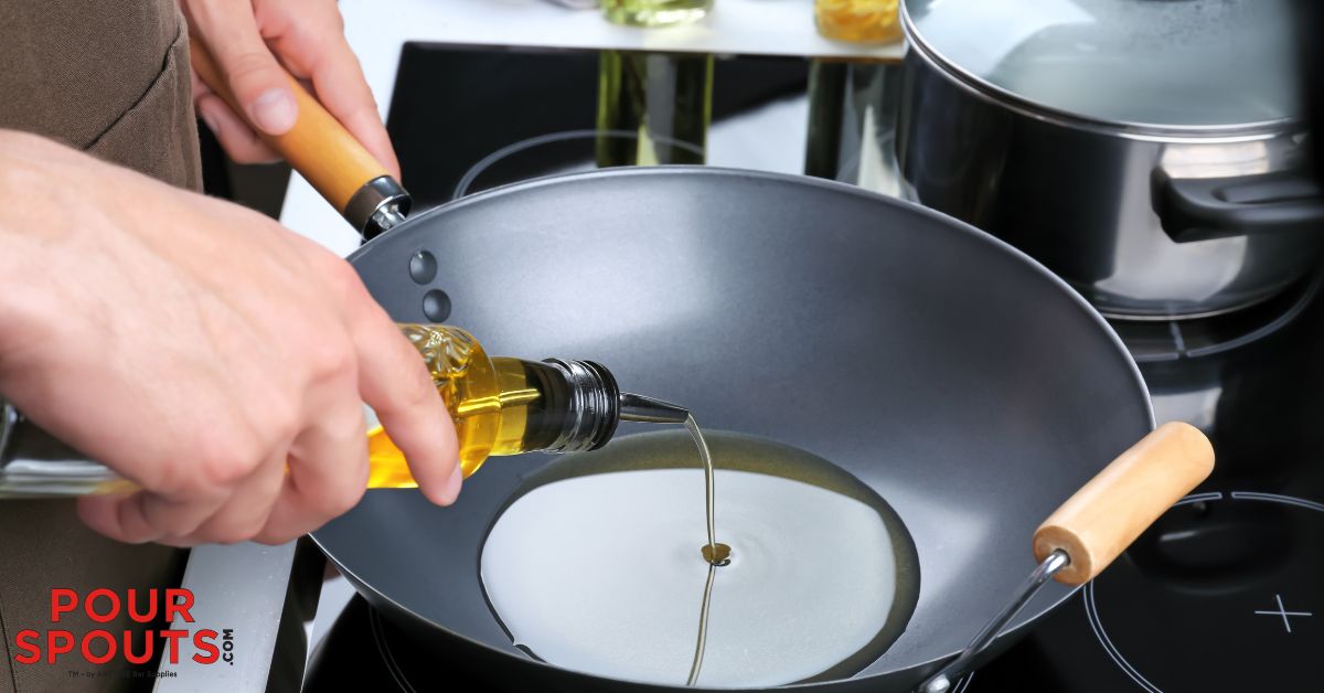 person pouring olive oil into a pan - Pour Spouts by Anytime Bar Supplies pour spouts