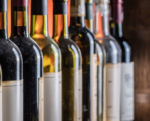 line up of different wine bottles near a wood barrel - Anytime Bar Supplies Pour Spouts stainless steel pour spout for wine