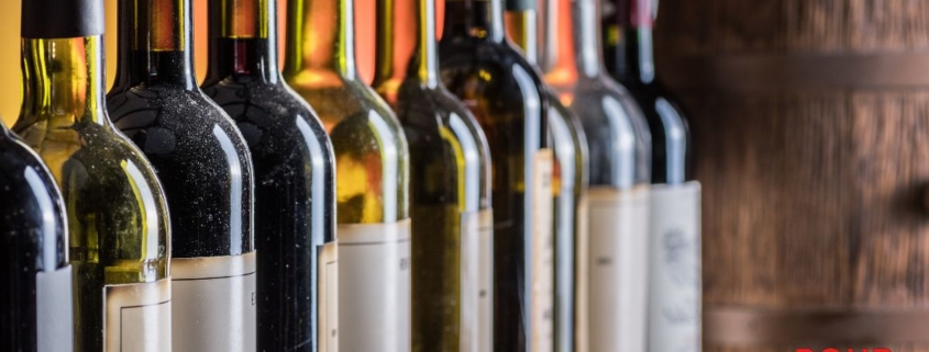 line up of different wine bottles near a wood barrel - Anytime Bar Supplies Pour Spouts stainless steel pour spout for wine