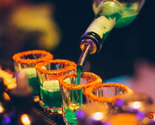 person pouring liquor into shot glasses - Anytime Bar Supplies Pour Spouts wholesale pour spouts