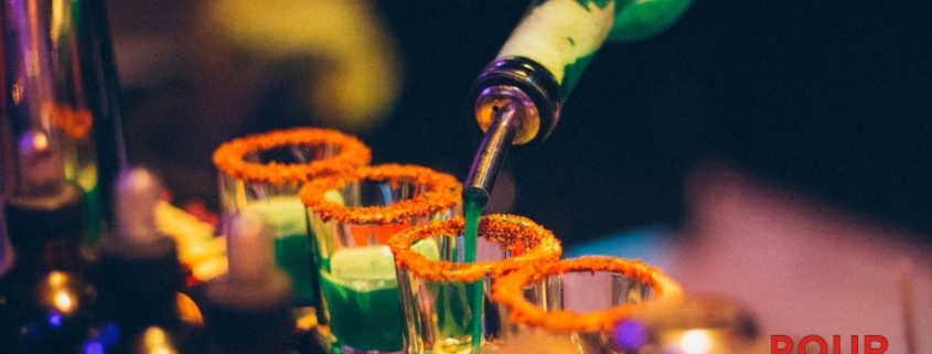 person pouring liquor into shot glasses - Anytime Bar Supplies Pour Spouts wholesale pour spouts