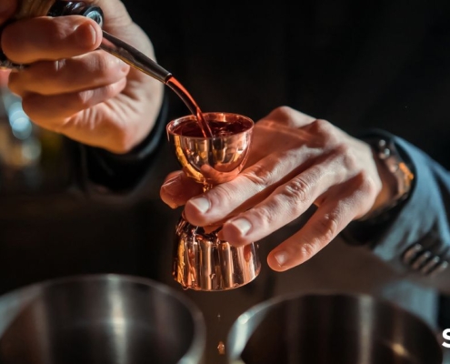 person pouring liquor into a copper shot measuring cup - Pour Spouts liquor bottle pour spout