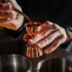 person pouring liquor into a copper shot measuring cup - Pour Spouts liquor bottle pour spout