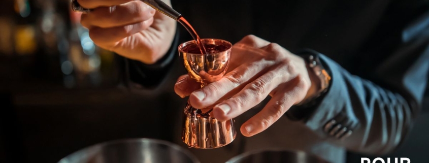 person pouring liquor into a copper shot measuring cup - Pour Spouts liquor bottle pour spout