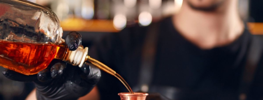 person pouring alcohol into a glass - Pour Spouts by Anytime Bar Supplies pour spout
