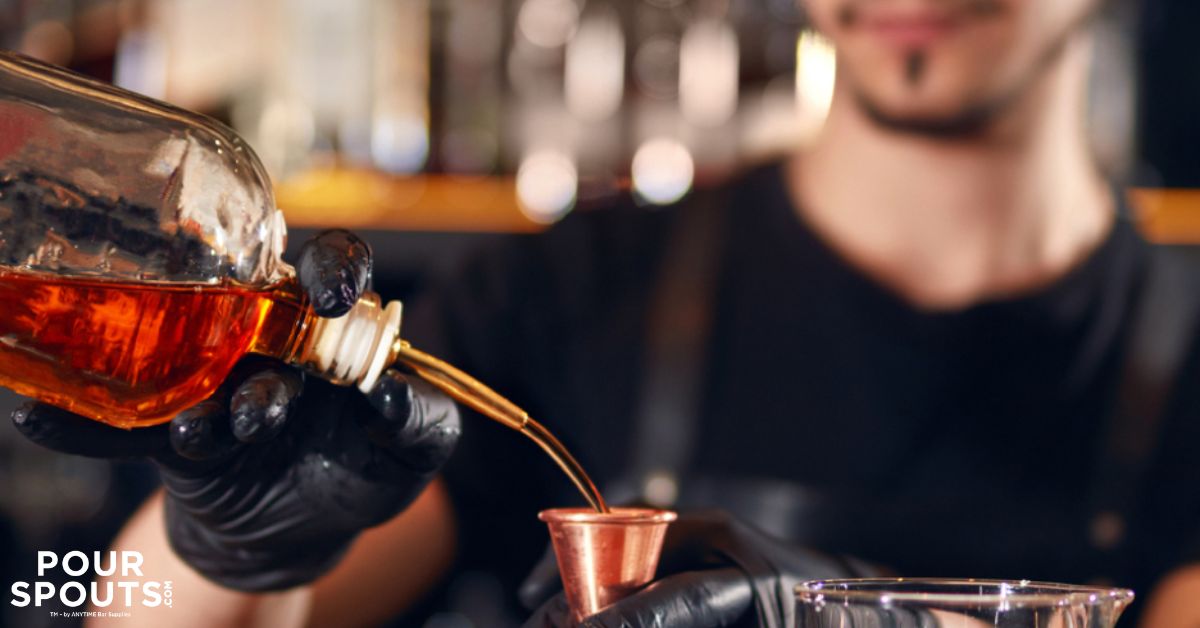 person pouring alcohol into a glass - Pour Spouts by Anytime Bar Supplies stainless steel pour spout for alcohol