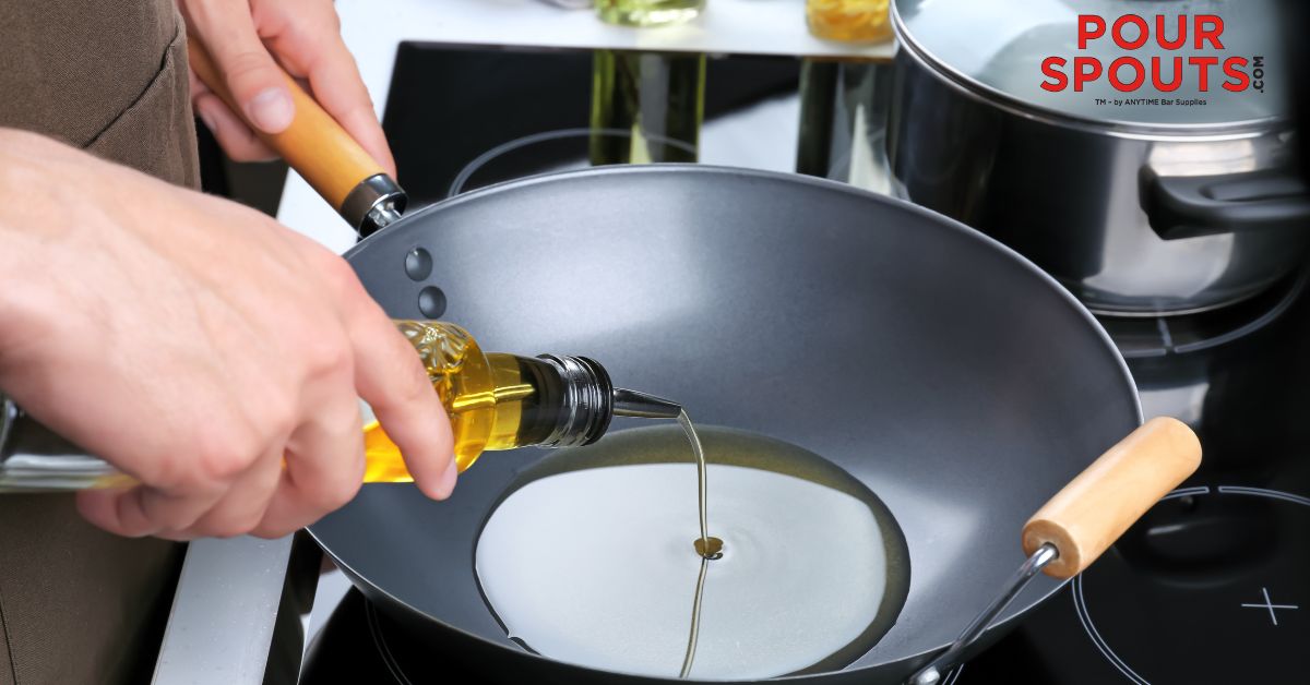 person pouring oil into a cooking fry pan - Anytime Bar Supplies Pour Spouts stainless steel pour spouts