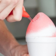 person pouring syrup over a snow cone - Pour Spouts