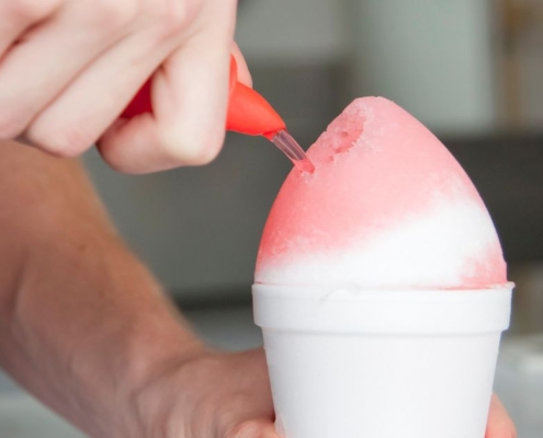 person pouring syrup over a snow cone - Pour Spouts