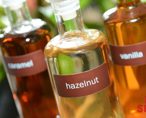 clear glass bottles containing coffee syrups - Pour Spouts for coffee syrups