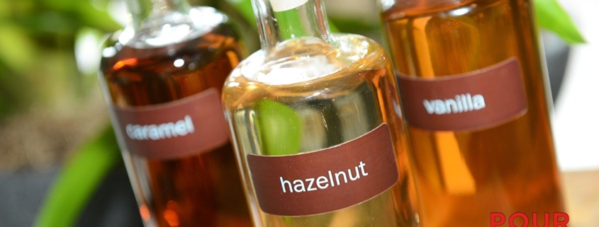 clear glass bottles containing coffee syrups - Pour Spouts for coffee syrups