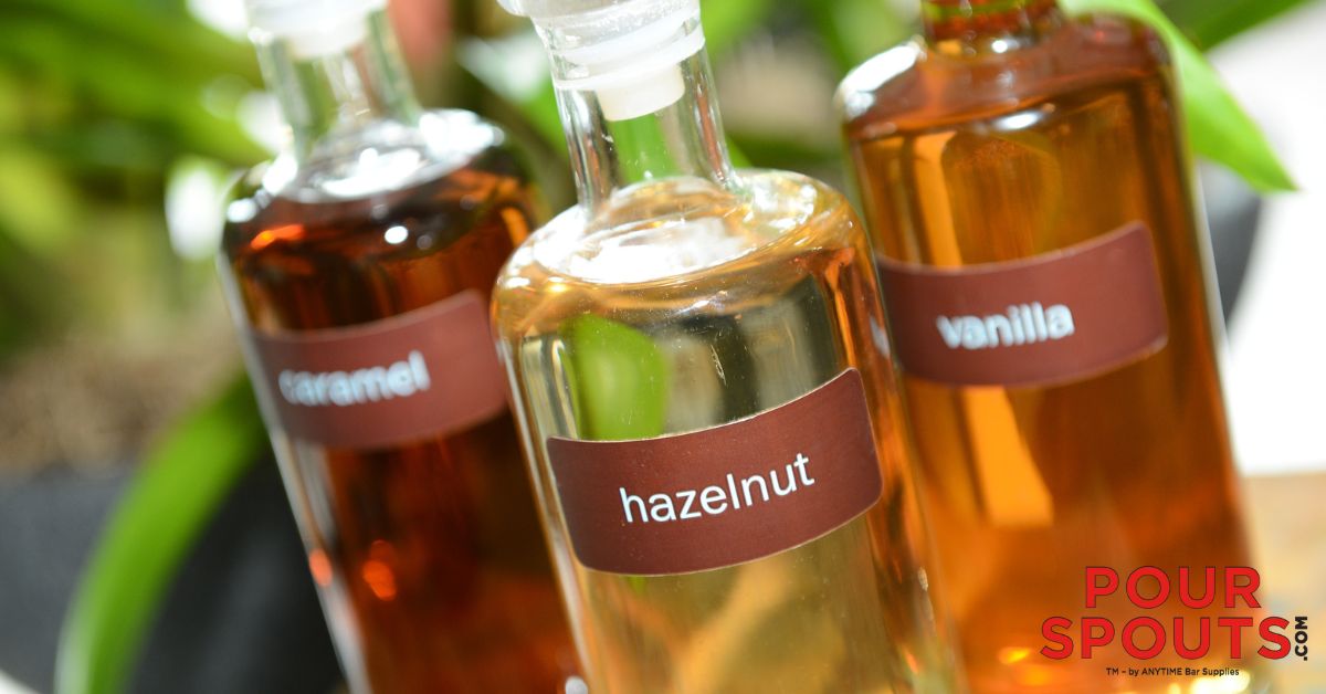 clear glass bottles containing coffee syrups - Pour Spouts for coffee syrups