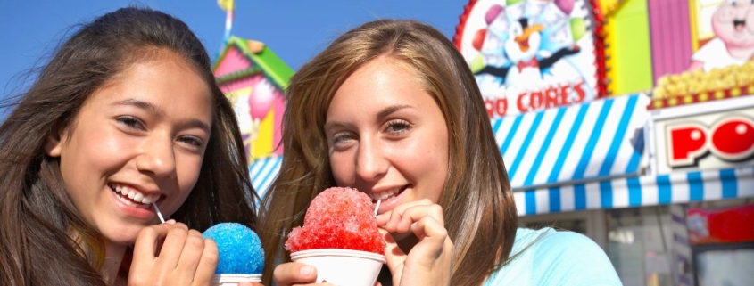 two girls at a fair eating snow cones - Pour Spouts