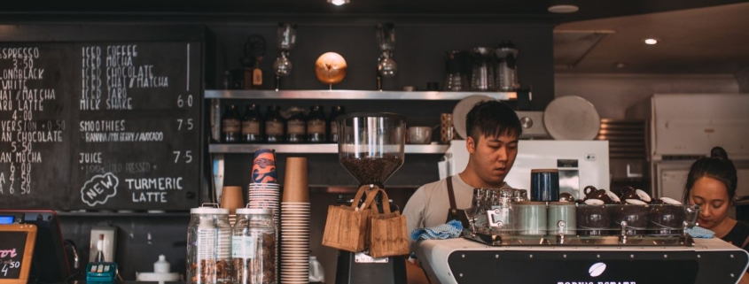 two individuals working at a coffee shop - Pour Spouts