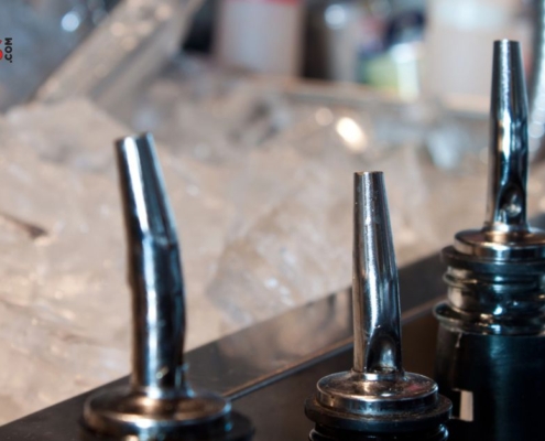silver pour spouts next to bucket of ice - Pour Spouts professional grade pourers