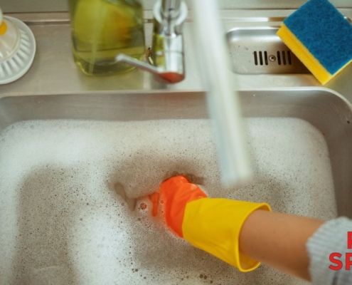 human hand with a glove in soapy sink water - Pour Spouts