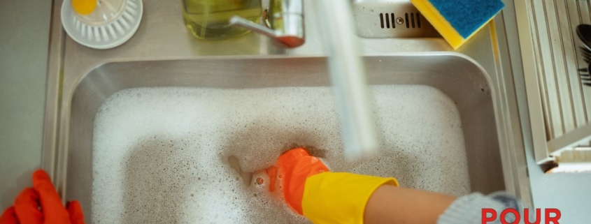 human hand with a glove in soapy sink water - Pour Spouts